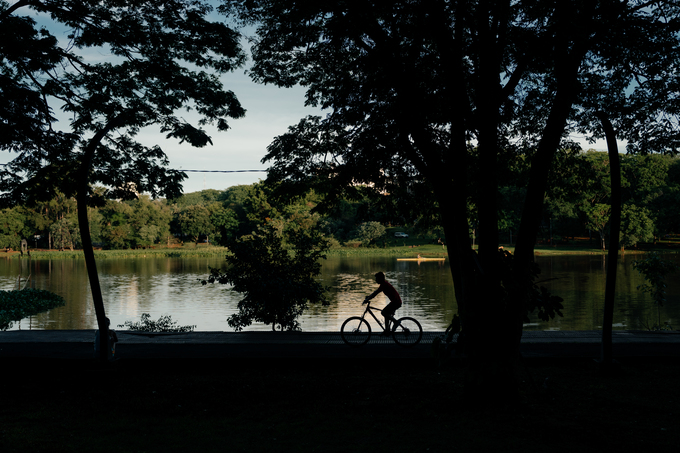 Persona en bicicleta junto a un lago rodeado de vegetación